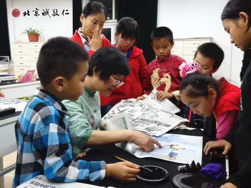 配圖：楊老師指導(dǎo)小學(xué)員書法要領(lǐng) 彩色較多的報(bào)紙不宜用來書寫