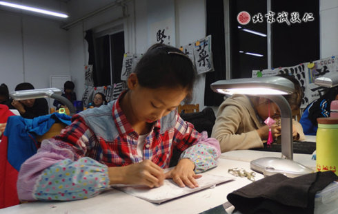 配圖：篆刻班里學(xué)員專注的習(xí)練篆刻，